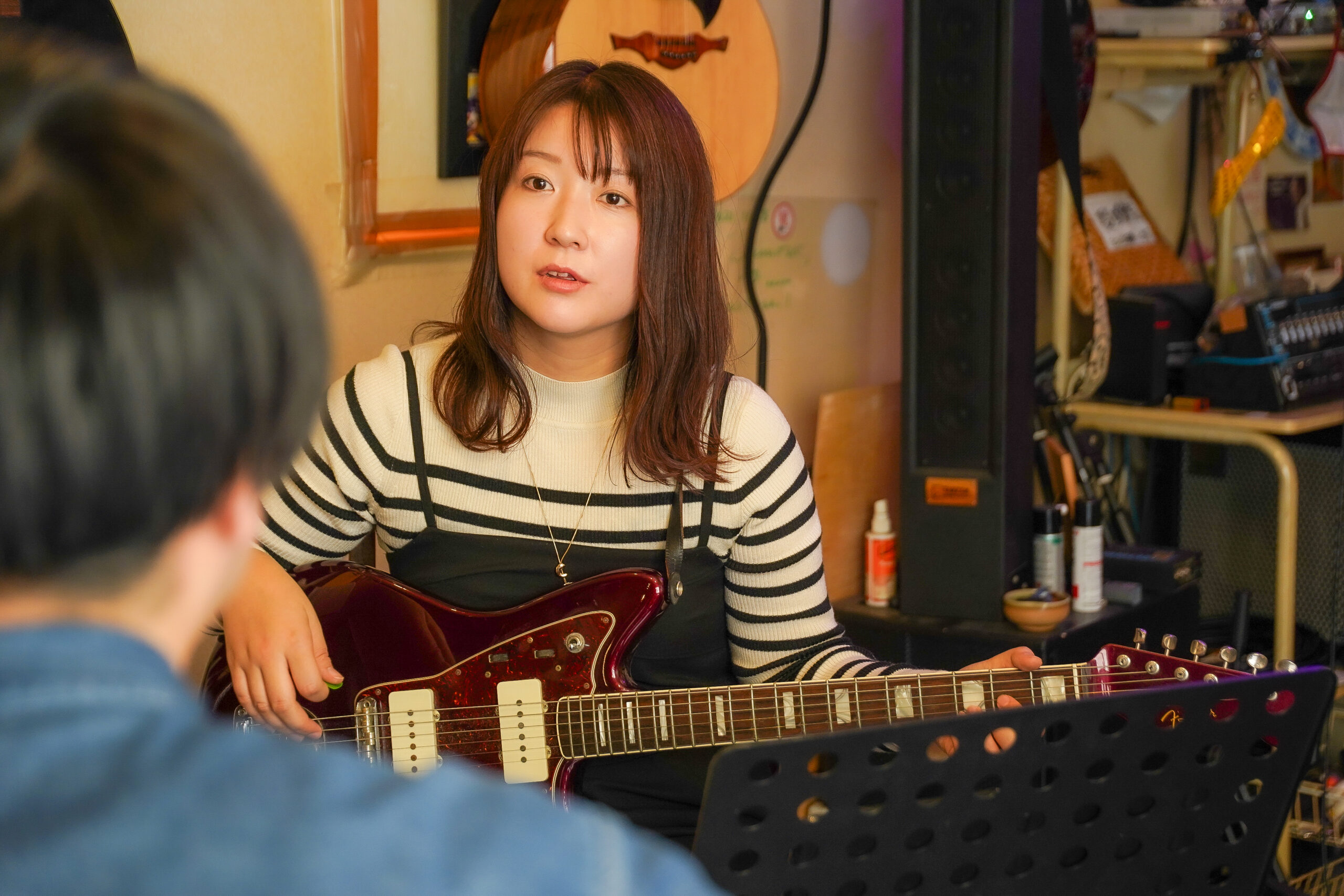 姪浜から通えるギター教室で大人の初心者が講師に質問している様子