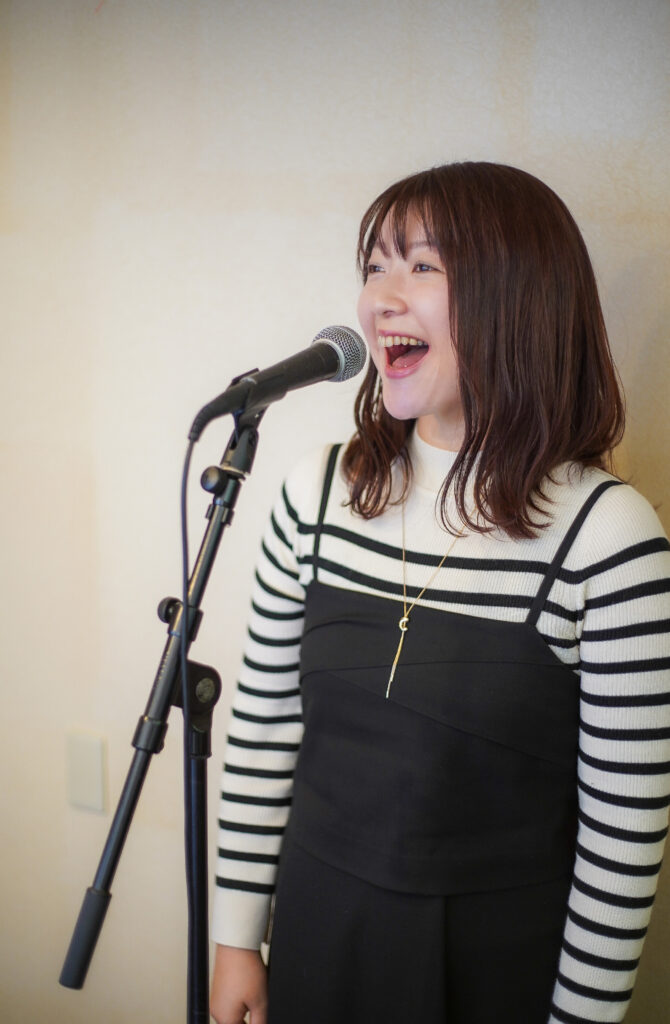 福岡市西区のボイトレ教室、TANNY音楽教室でマイクを持って笑顔で歌う大人の女性生徒さん