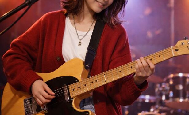 エレキギターを笑顔で弾く初心者の女性|福岡市西区のTANNY音楽教室