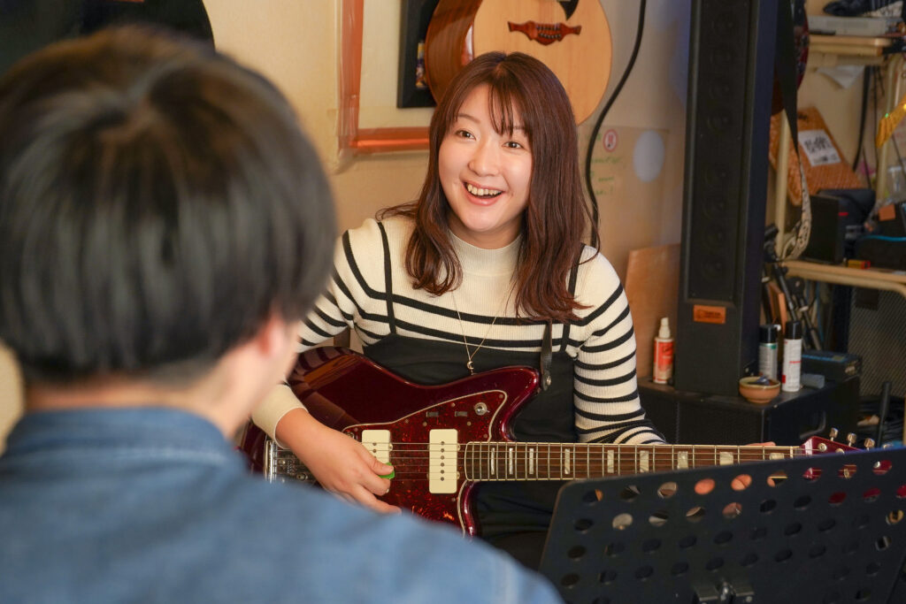 姪浜の音楽教室で初心者がギターのレッスンを受けている風景