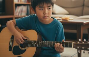 姪浜のギター教室「TANNY音楽教室」でレッスンを受ける、ギター初心者のお子様。指の痛みや力みに悩んでいる様子。