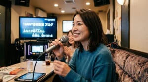 カラオケボックスでマイクを持ち笑顔で歌う女性と喉のケアを解説するTANNY音楽教室のアイキャッチ画像
